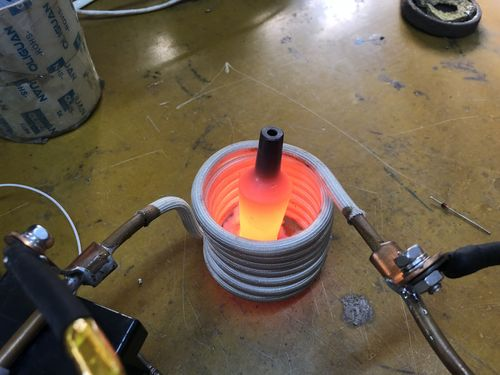 Portable single burner electric hot plate with a visible Nichrome wire coil glowing red.